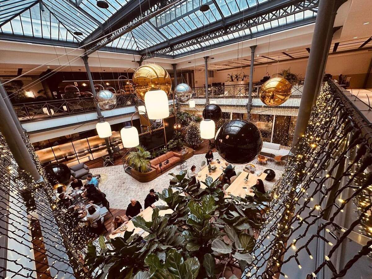 Ballons miroirs dorés et noirs dans un grand atrium