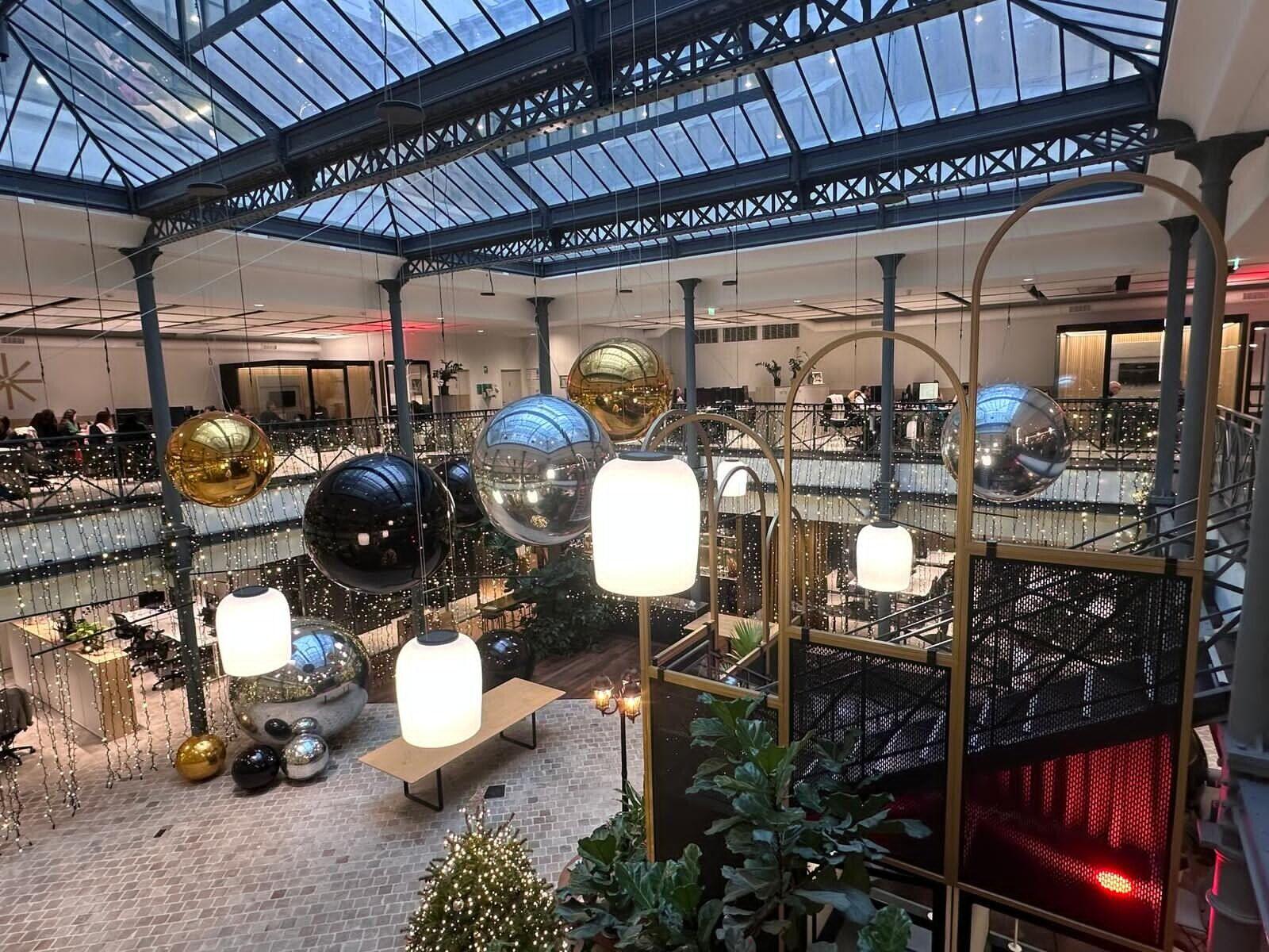 Ballons miroirs dorés, argentés et noirs dans un atrium