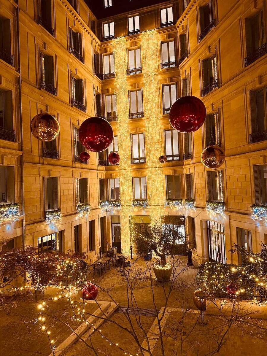 Ballons miroirs rouges et dorés dans une cour illuminée