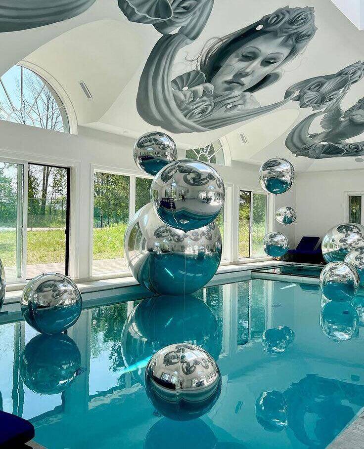 Ballons miroirs argentés installés autour d’une piscine intérieure