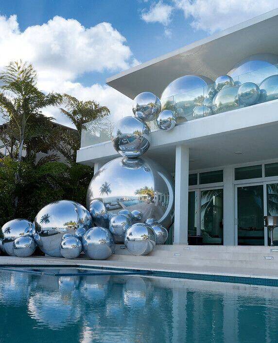 Ballons miroirs argentés installés autour d’une piscine extérieure