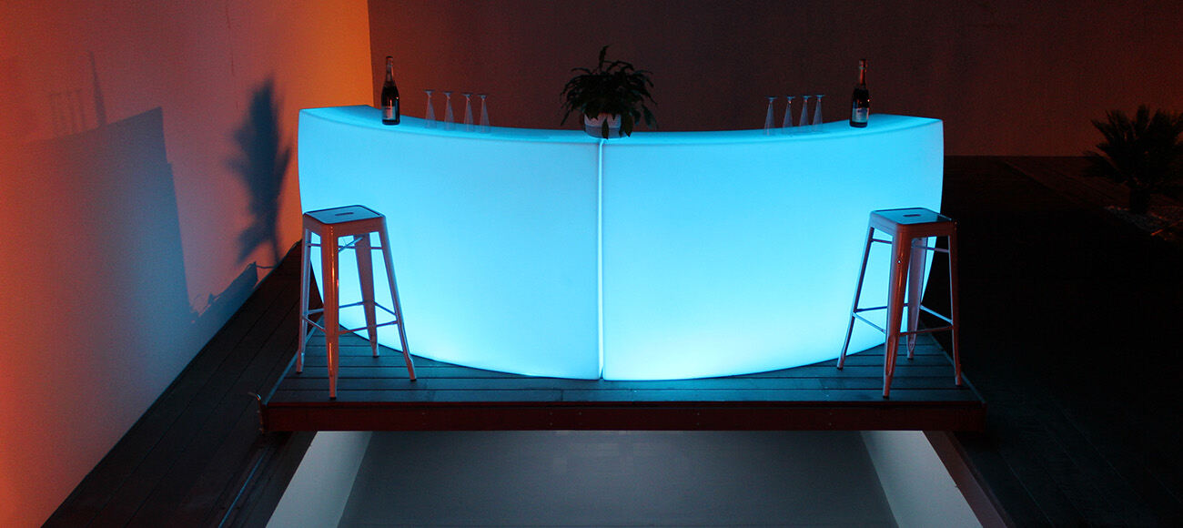 Double bar lumineux arrondi bleu montrant la forme courbe du mobilier
