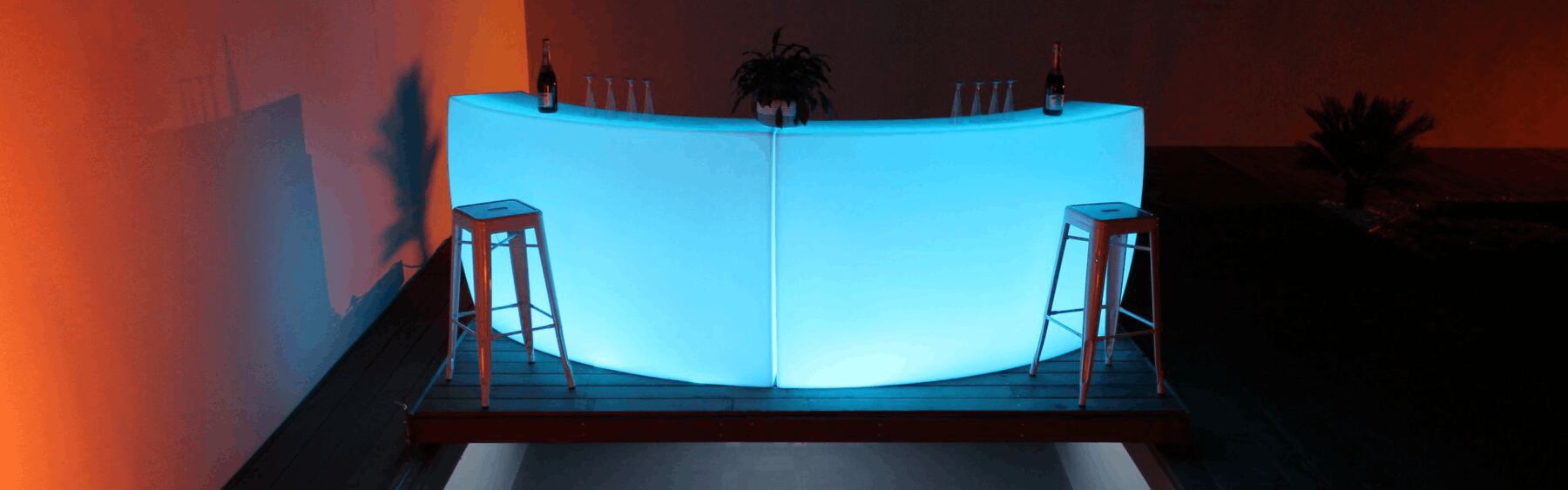 Bar lumineux arrondi bleu installé au bord d’une piscine