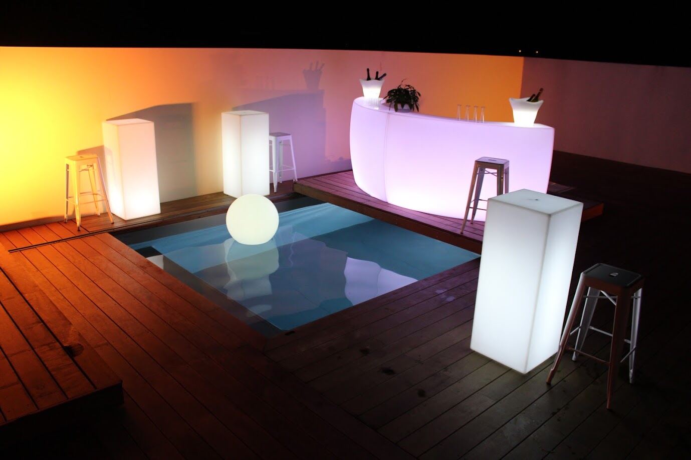 Ensemble de mobilier lumineux autour d’une piscine