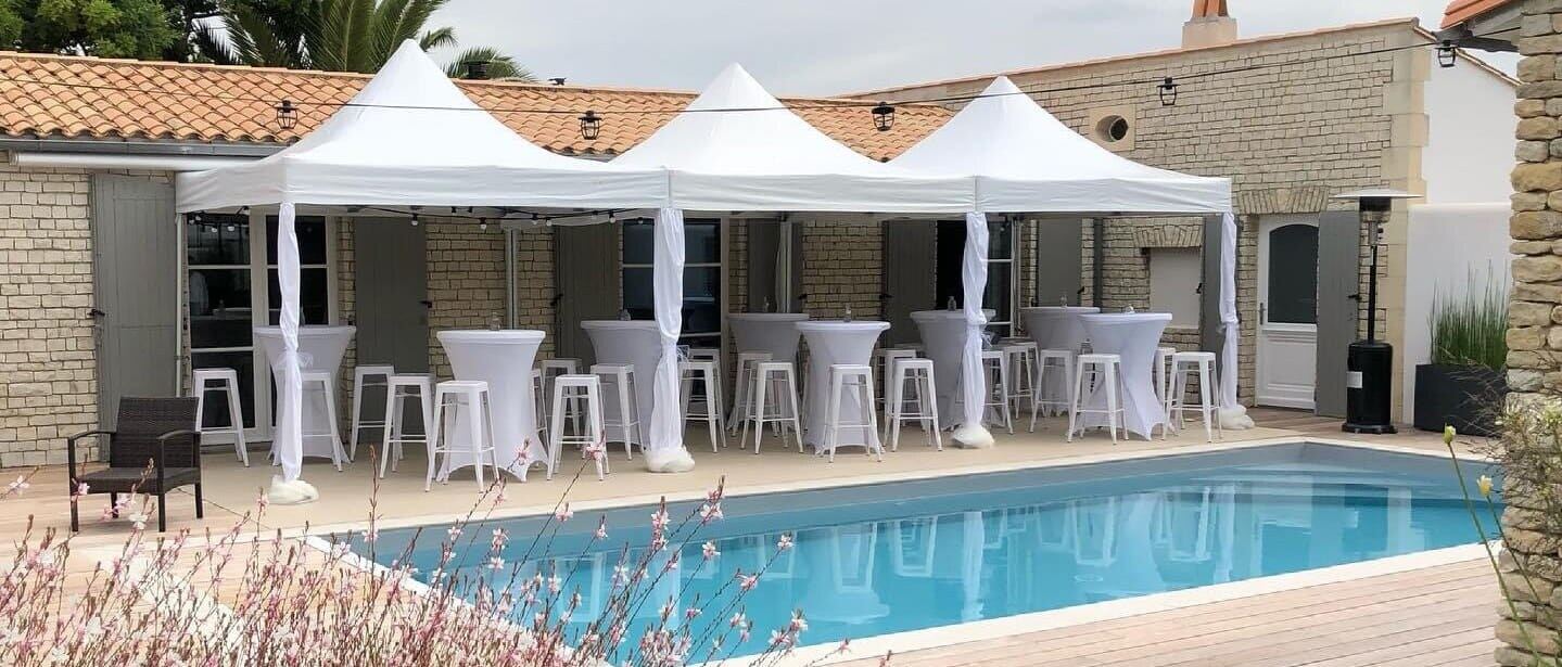 Barnums blancs avec mange-debout au bord d’une piscine