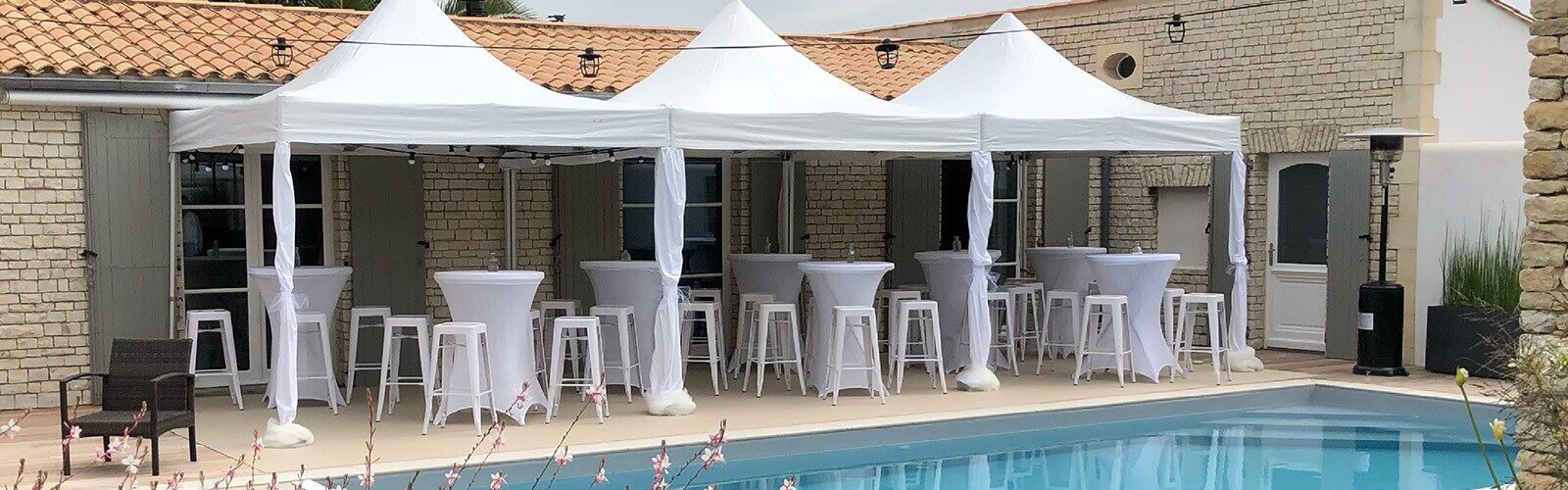 Barnums et mobilier cocktail installés au bord d’une piscine