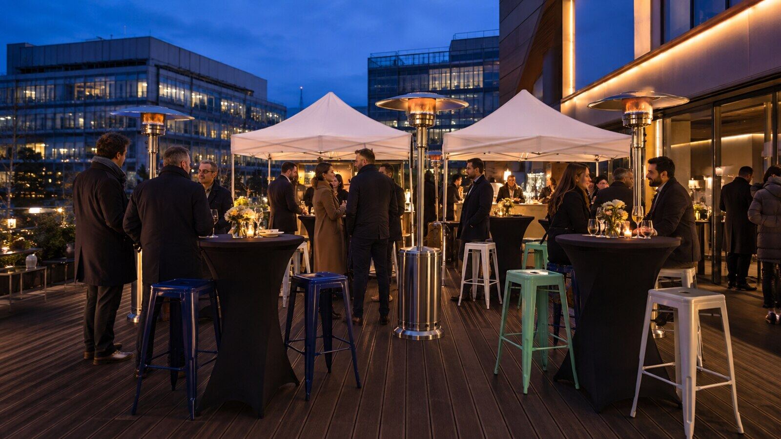 Barnums blancs et mobilier cocktail sur une terrasse en soirée