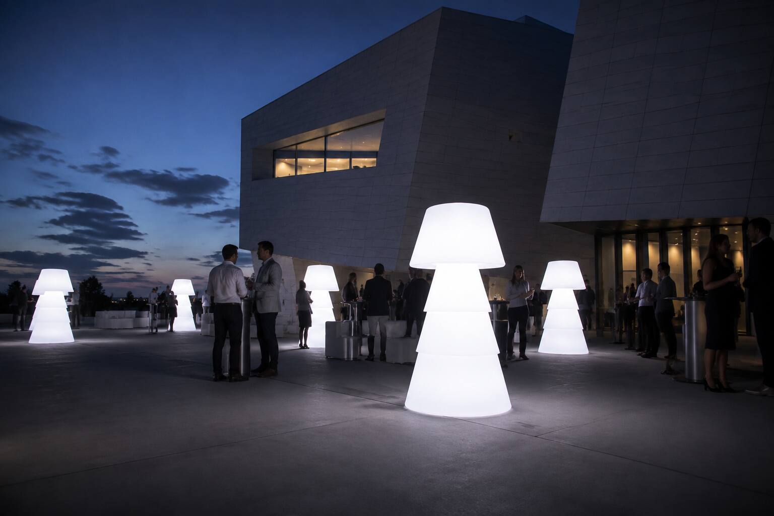 Lampadaires lumineux dans la cour d’un bâtiment moderne lors d’un cocktail