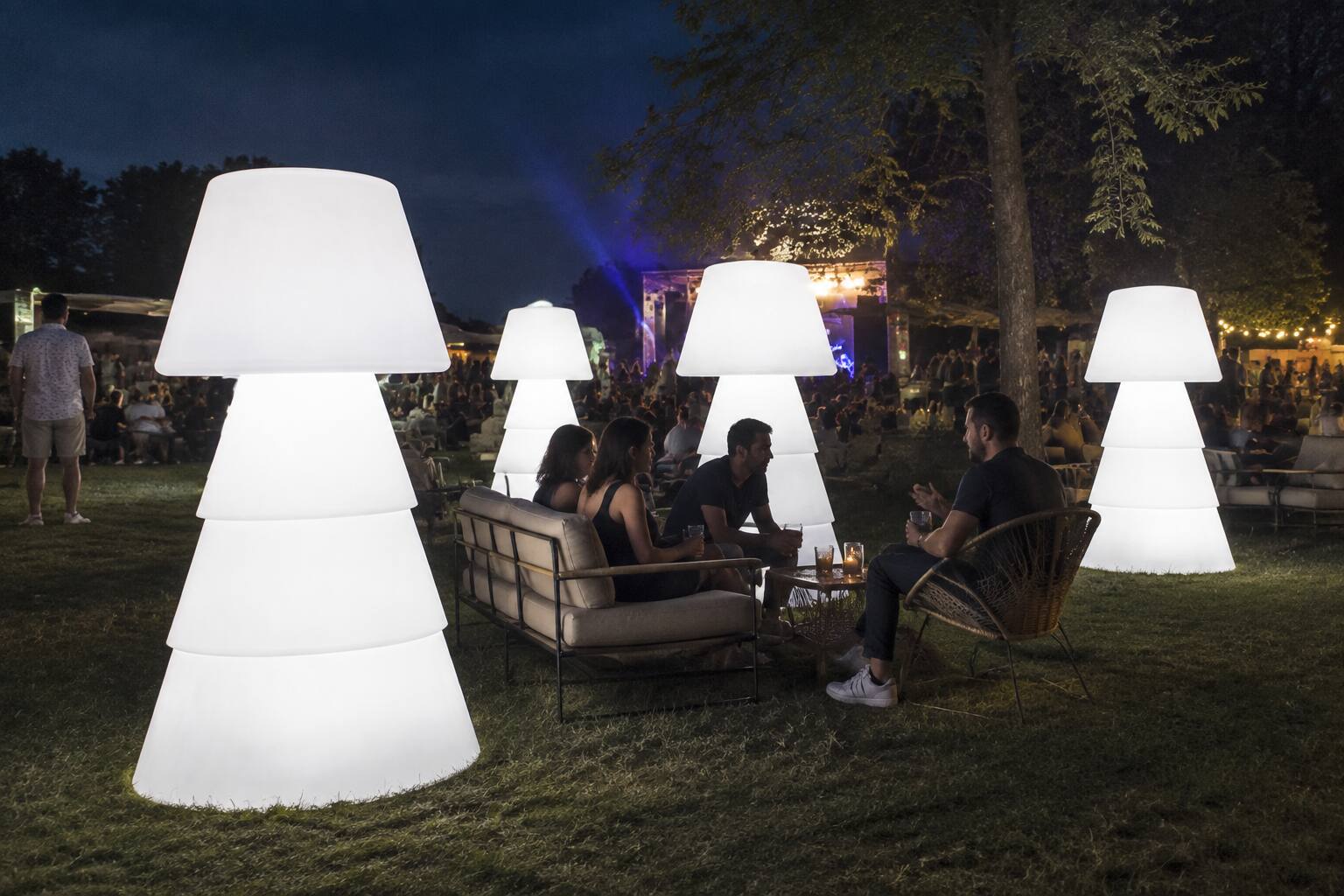 Lampadaires lumineux XL dans un jardin lors d’un événement musical