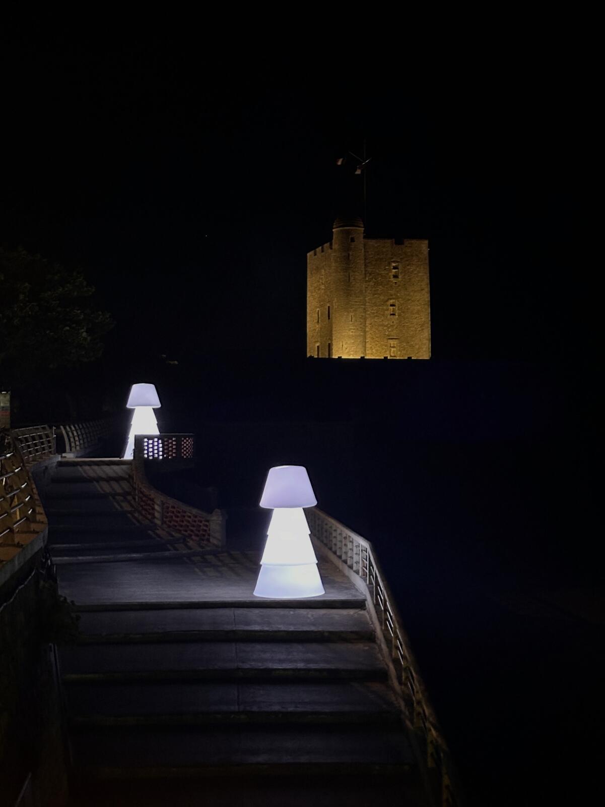 Deux lampadaires LED blancs installés devant un fort de nuit