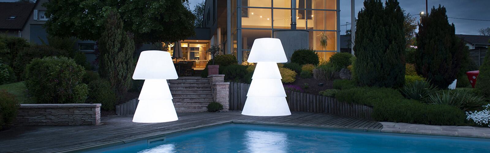 Deux lampadaires LED XL blancs éclairant une terrasse au bord d’une piscine