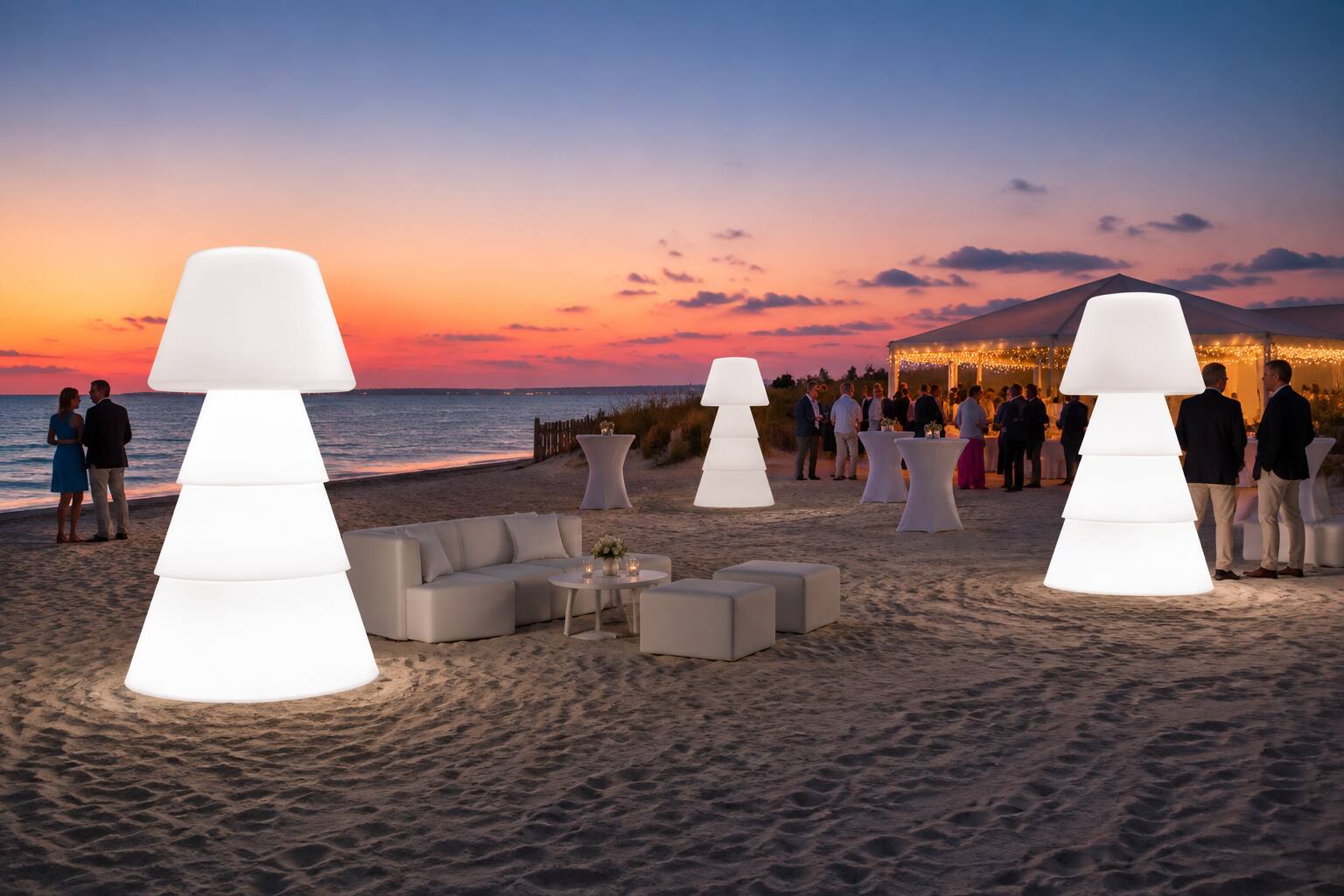 Lampadaires LED géants sur une plage lors d’une réception au coucher du soleil