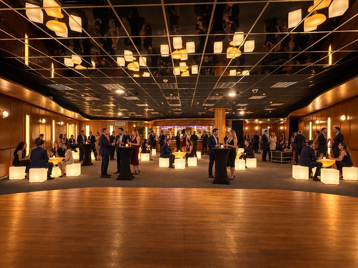 Salle de réception avec invités, tables Lounge ambrées et assises lumineuses ivoire