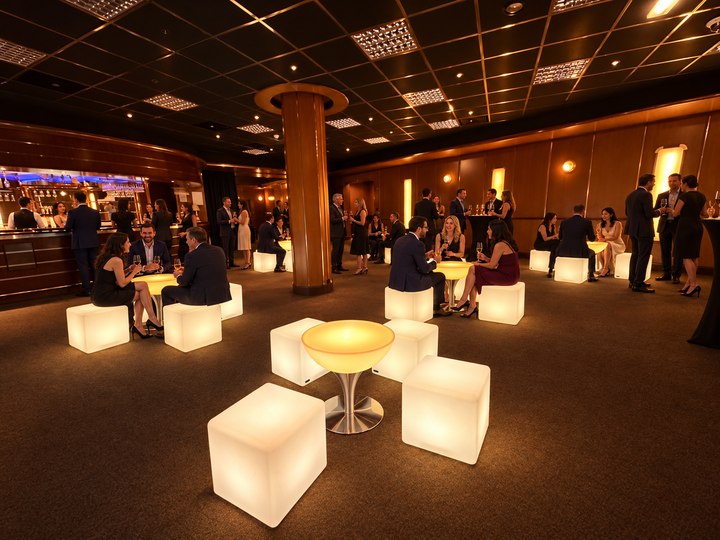 Table Lounge ambrée et quatre cubes lumineux ivoire dans un salon avec public