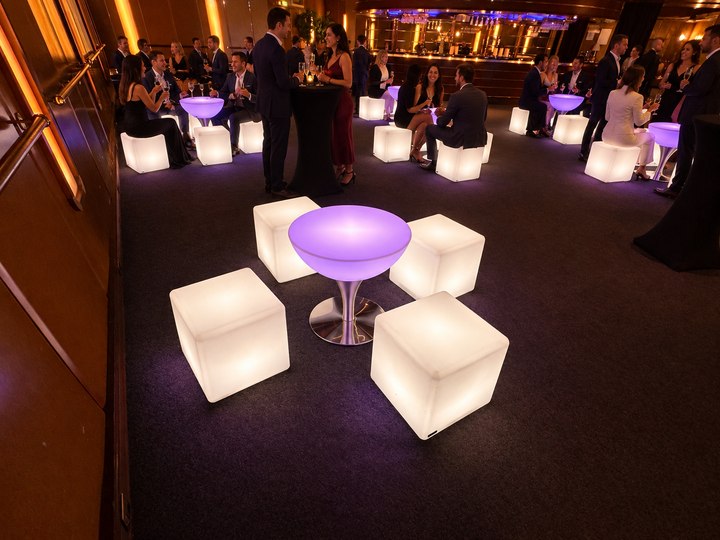 Table basse Lounge lavande au premier plan avec cubes perle et convives