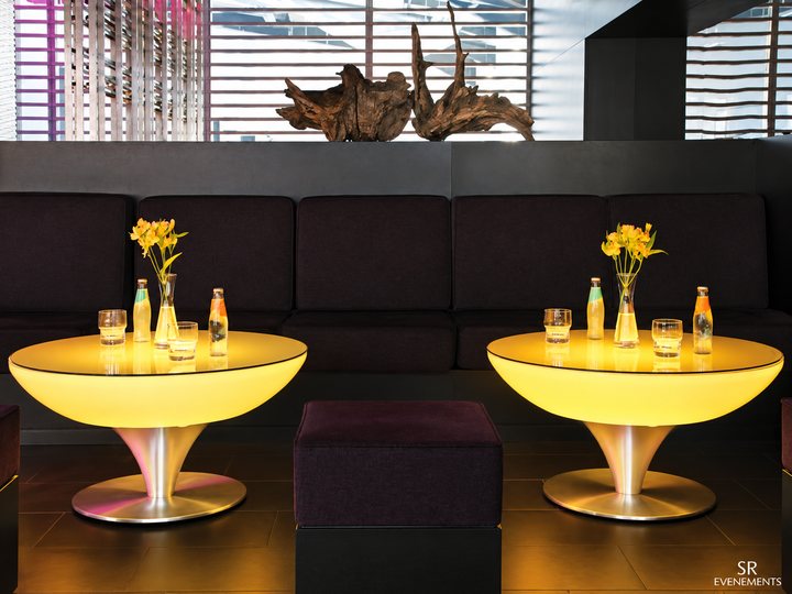 Deux tables basses Lounge ambrées sur pied en inox devant un canapé