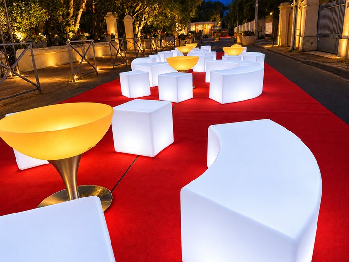 Table Lounge lumineuse ambrée près d’un banc lumineux blanc