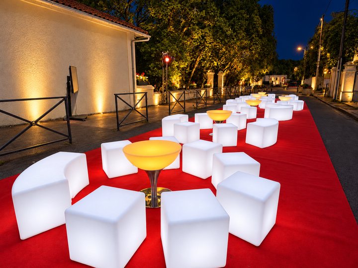 Tables basses Lounge ambrées parmi des cubes et bancs lumineux blancs