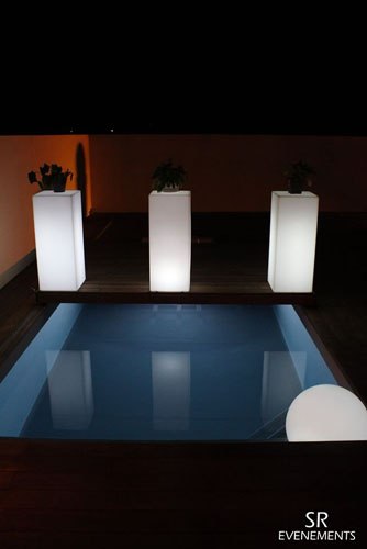 Tables hautes lumineuses au bord d’une piscine