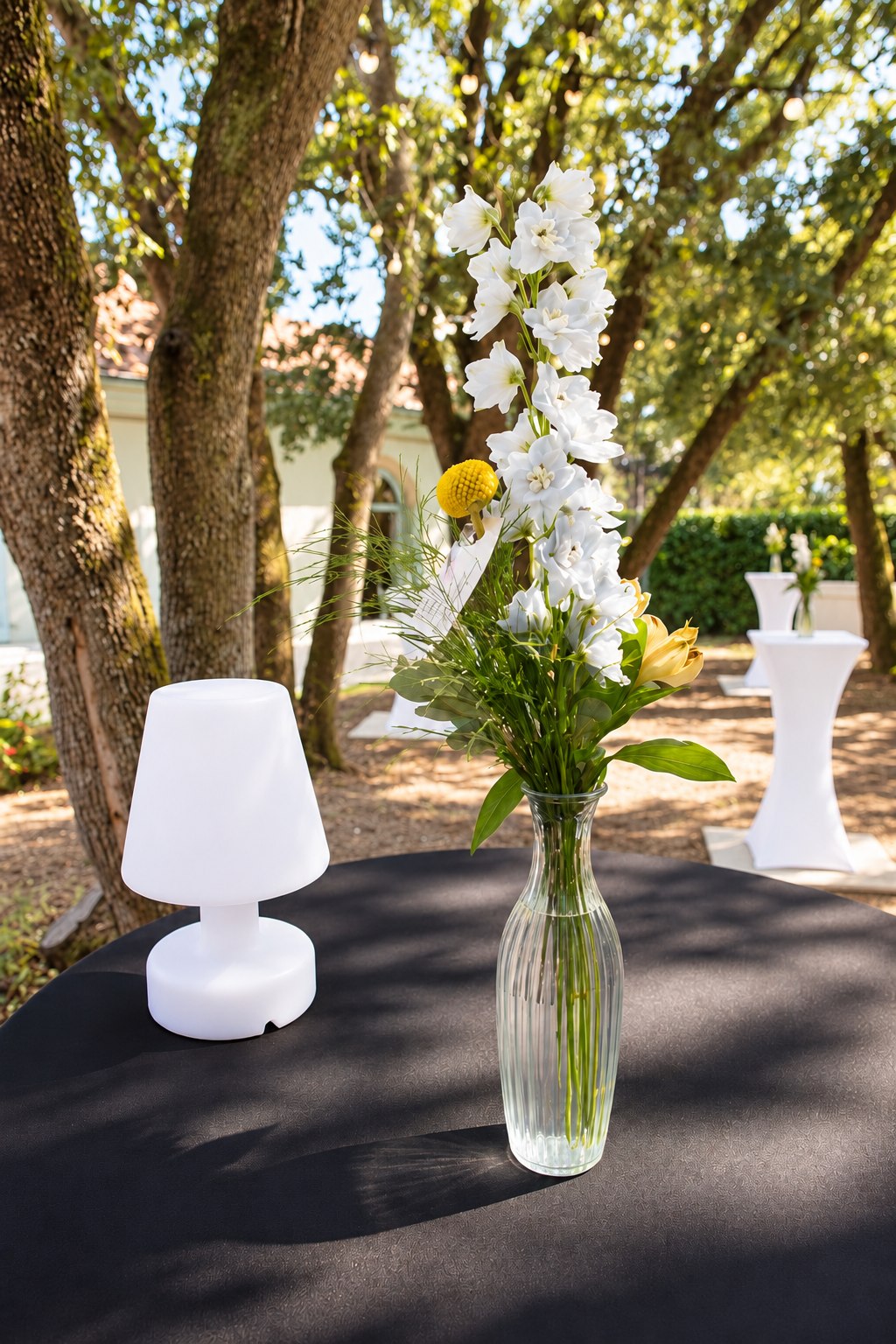 Vase de fleurs et lampe de table devant des mange-debout blancs