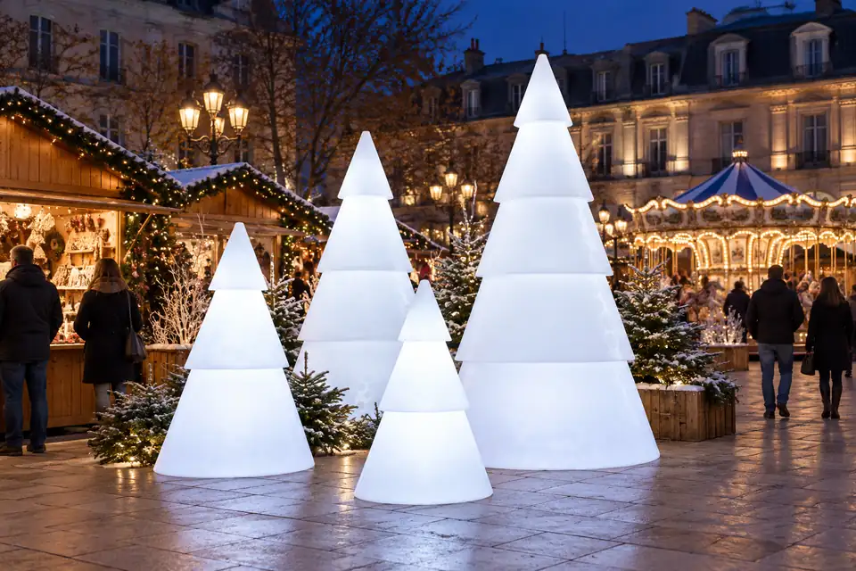 Quatre sapins lumineux Modulo blanc froid au cœur d’un marché de Noël