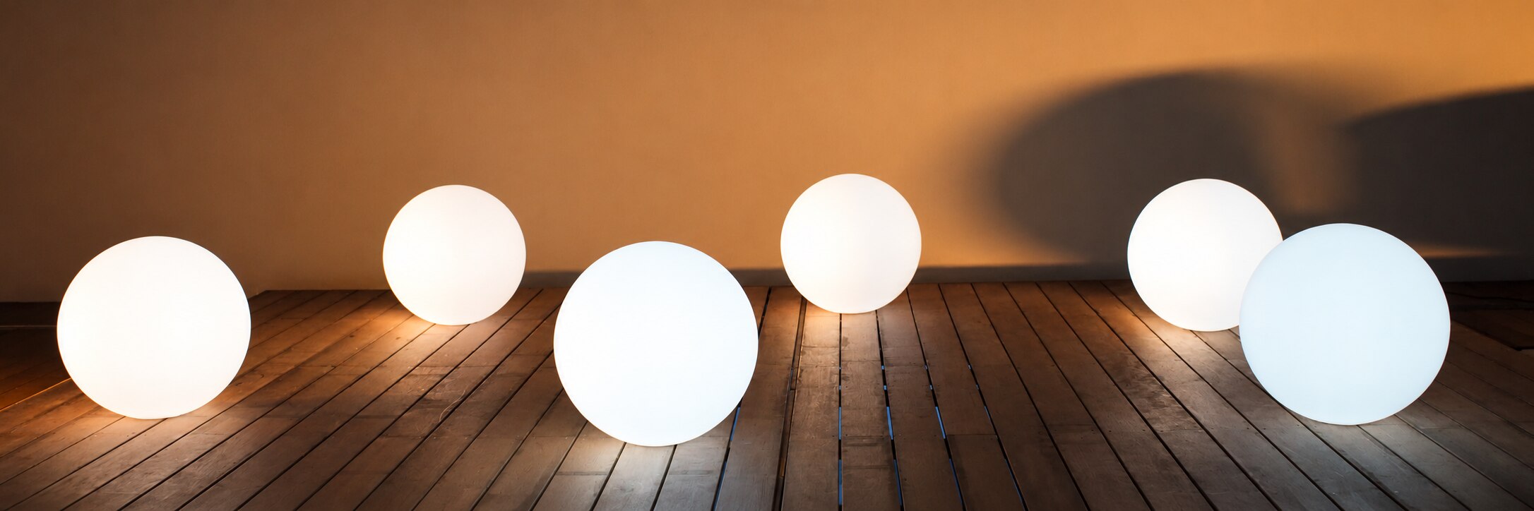 Sphères blanches sur une terrasse en bois — installation SR Événements.