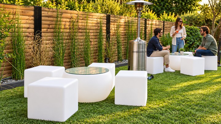 Tables basses rondes avec plateau en verre et cubes blancs dans un jardin