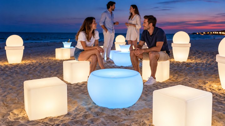 Table basse ronde lumineuse bleue et cubes blancs pour un cocktail sur la plage