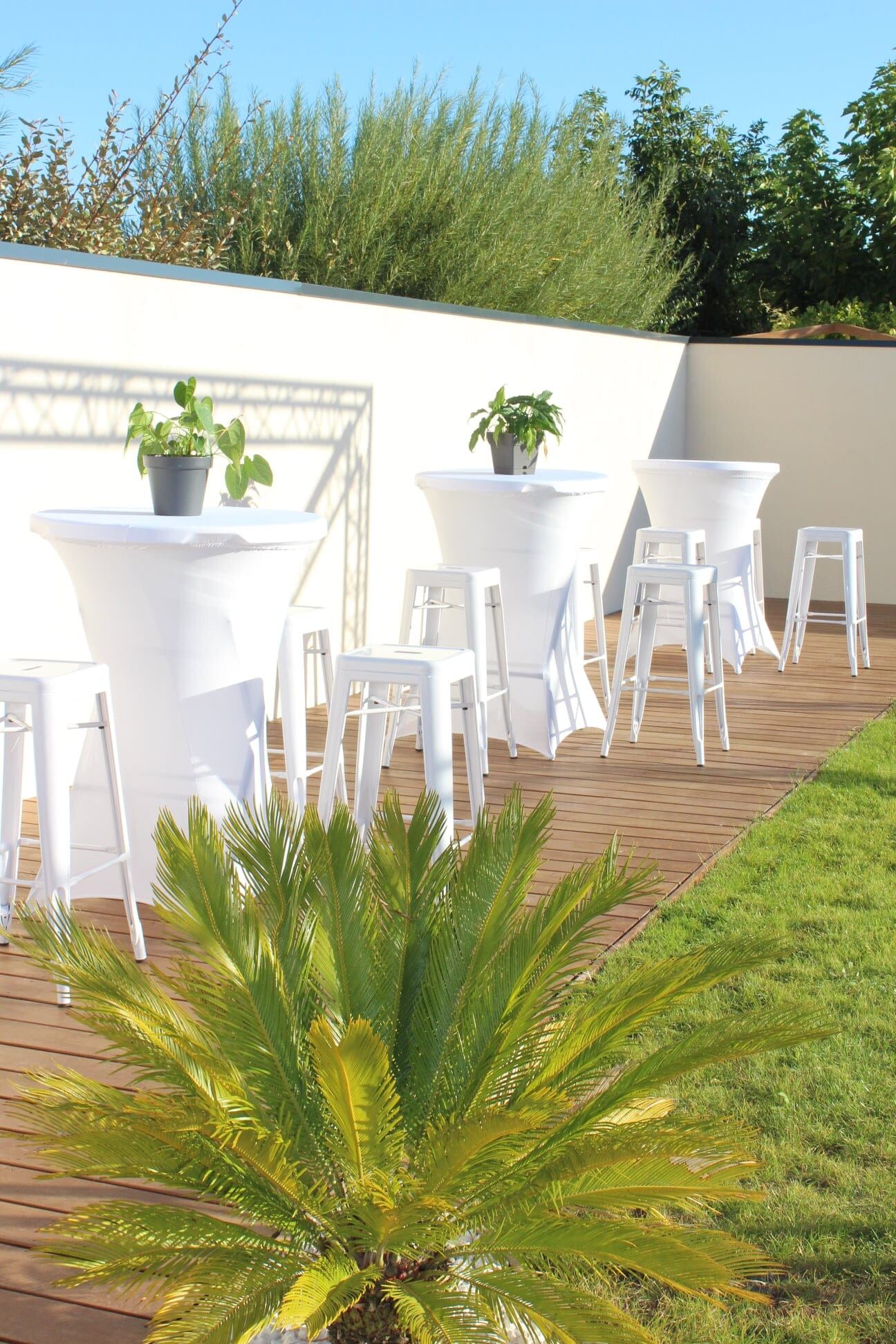 Vue verticale de tabourets hauts acier blancs et mange-debout dans un jardin