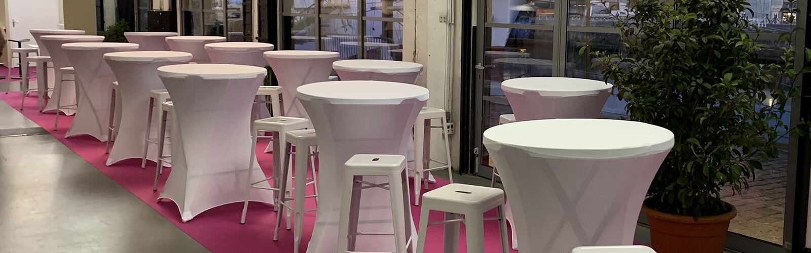 Tabourets hauts acier blancs et mange-debout sur un salon professionnel