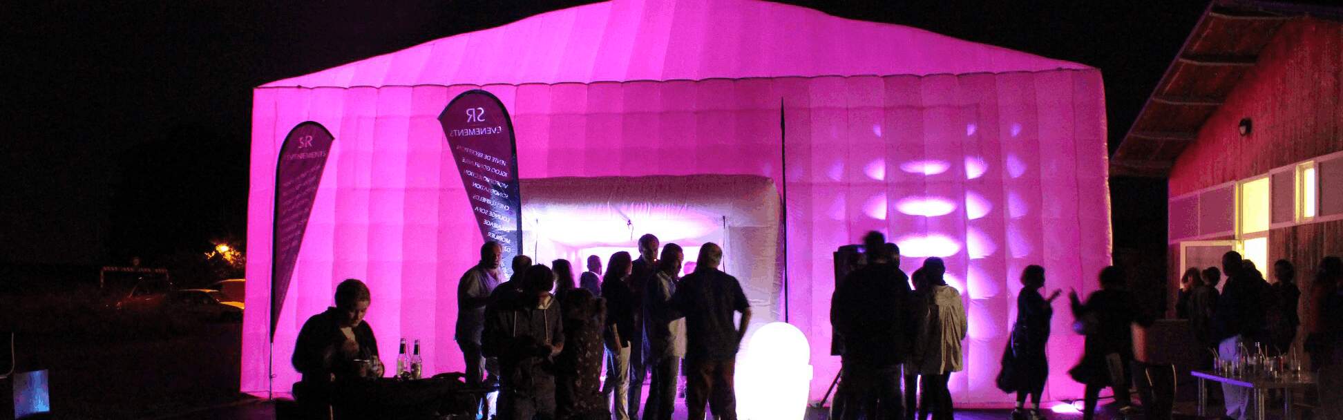 Façade de tente gonflable mise en lumière rose autour d’une porte XL