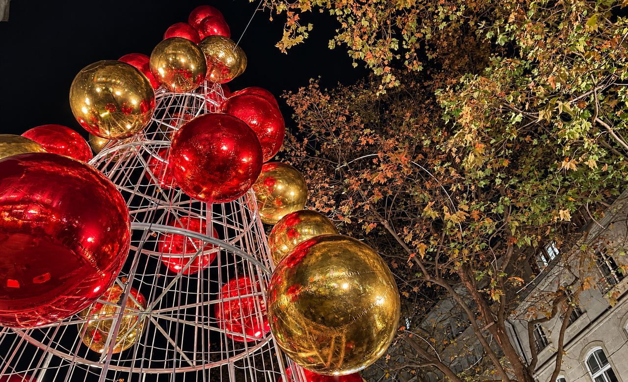 Structure en forme de sapin ornée de grands ballons miroirs rouges et dorés