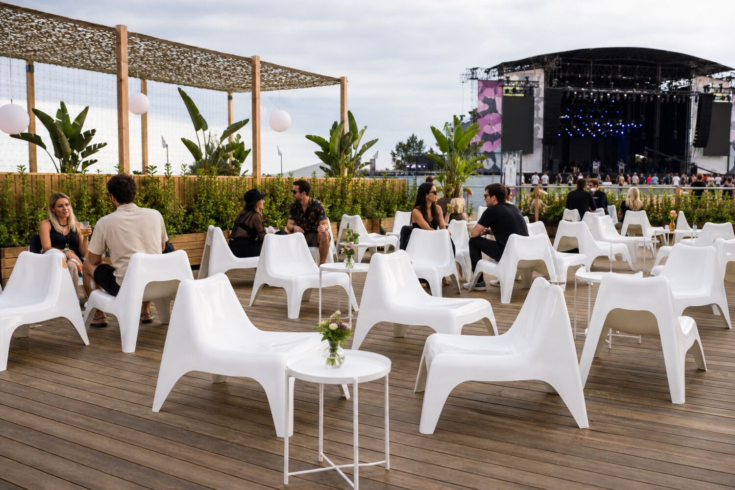 Zone lounge équipée de fauteuils Vago devant une scène de festival