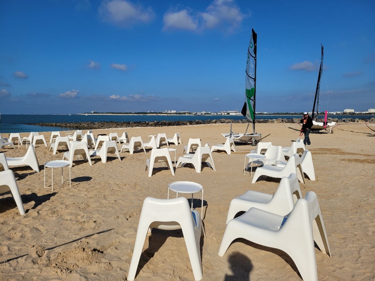 Fauteuils Vago installés sur le sable près de catamarans
