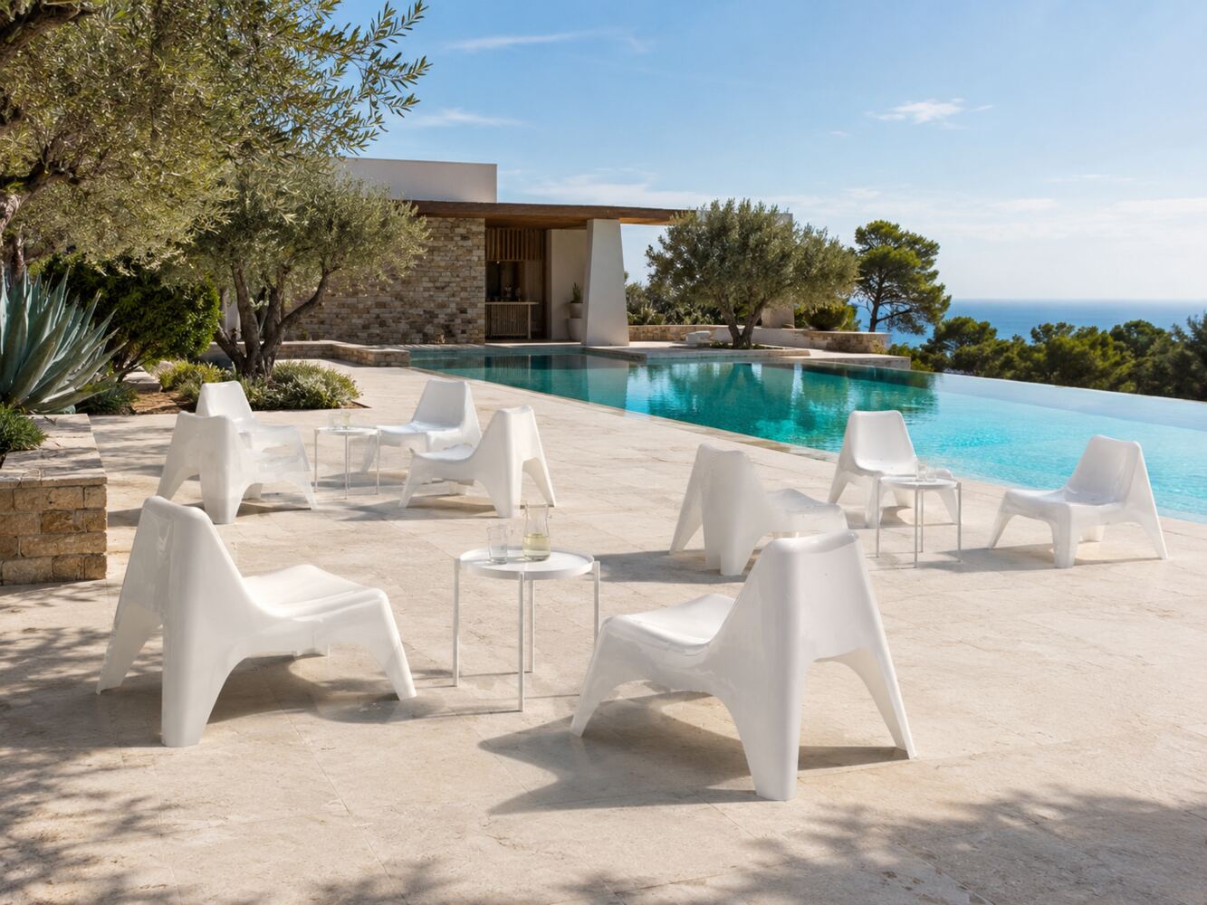 Fauteuils Vago blancs disposés autour d’une piscine